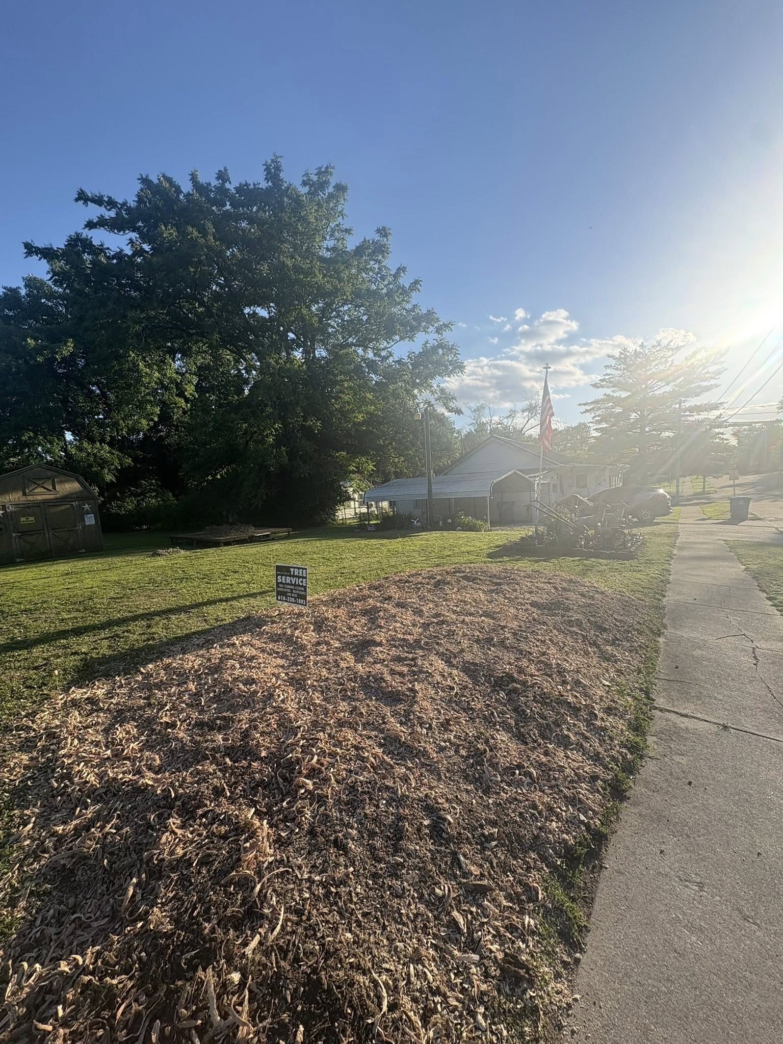 Completed job, fresh mulch and yard sign in the front lawn at sunset